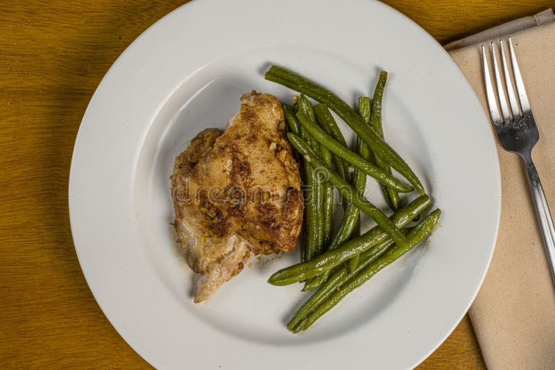 Baked chiken thigh served with sauteed green beens. Baked chiken thigh served with sauteed green beens