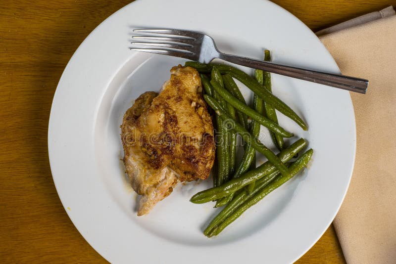 Baked chiken thigh served with sauteed green beens. Baked chiken thigh served with sauteed green beens