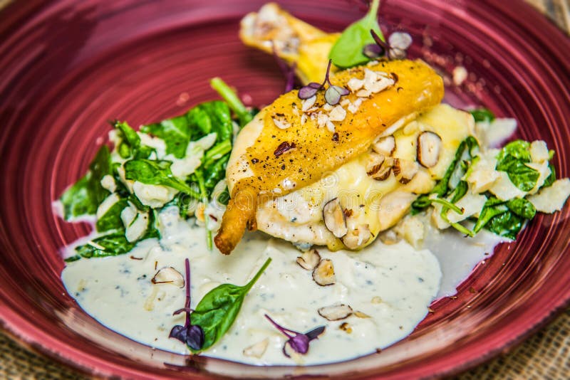 Chicken thigh stuffed with cheese on cream sauce.The food in the restaurant. Food styling and restaurant meal serving. Chicken thigh stuffed with cheese on cream sauce.The food in the restaurant. Food styling and restaurant meal serving