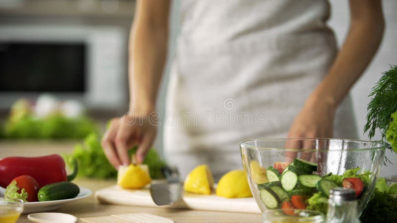 Cuisson de l'amateur faisant la cuisine fraîche de salade à la maison, s'habillant avec le jus de citron photo stock Cuisson de l'amateur faisant la cuisine fraîche de salade à la maison, s'habillant avec le jus de citron photo stock