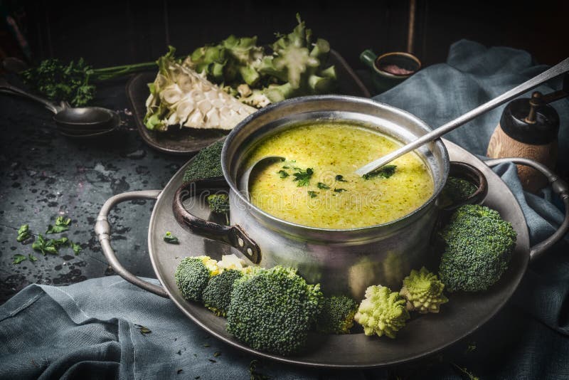 Cuisson du pot avec le romanesco et la soupe et la poche verts à brocoli sur la table de cuisine rustique foncée Nutrition saine