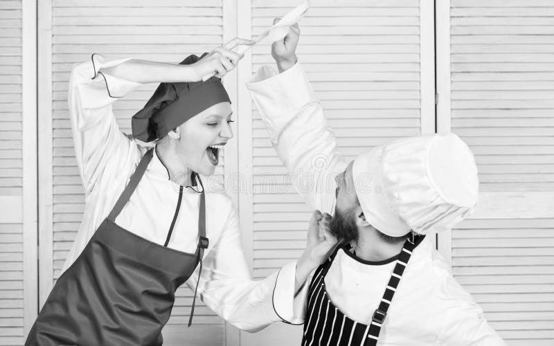Culinaire slag van twee chef-koks Het paar concurreert in culinaire arts. Keukenregels Who betere kok Culinair slagconcept royalty-vrije stock foto's Culinaire slag van twee chef-koks Het paar concurreert in culinaire arts. Keukenregels Who betere kok Culinair slagconcept royalty-vrije stock foto's