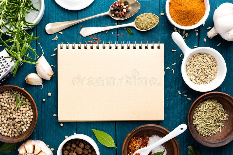 Culinary background and recipe book with spices on wooden table