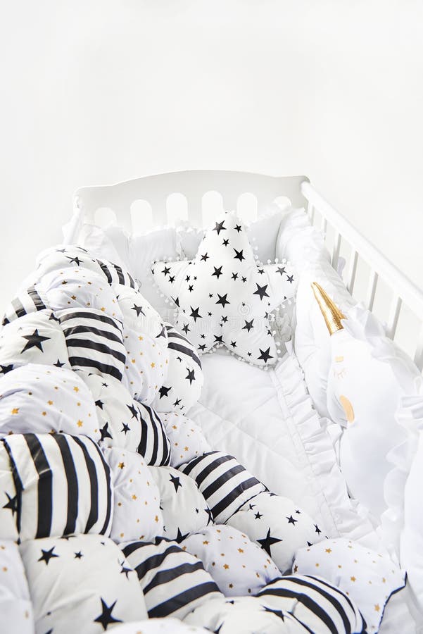 Culla di bambino accogliente con la coperta a forma di stella del piumino della rappezzatura e del cuscino con le stelle e le ban immagini stock Culla di bambino accogliente con la coperta a forma di stella del piumino della rappezzatura e del cuscino con le stelle e le ban immagini stock