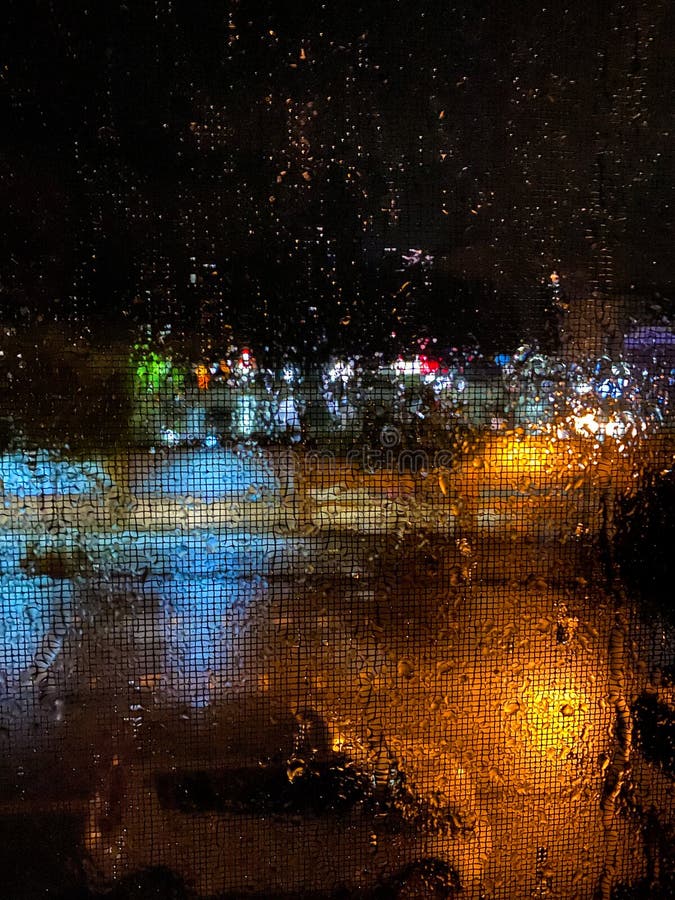Culorile abstracte reflectă în ploaie pe verticală pe timp de noapte stock images
