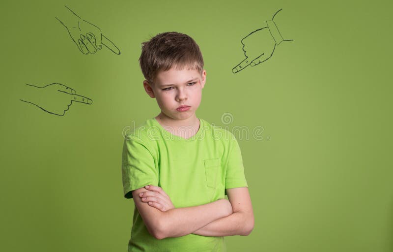 Guilty. Concept of accusation guilty person teen boy. Sad upset kid looking down with arms crossed, sketch fingers hands pointing at him. Human face expression emotion feeling. Guilty. Concept of accusation guilty person teen boy. Sad upset kid looking down with arms crossed, sketch fingers hands pointing at him. Human face expression emotion feeling.