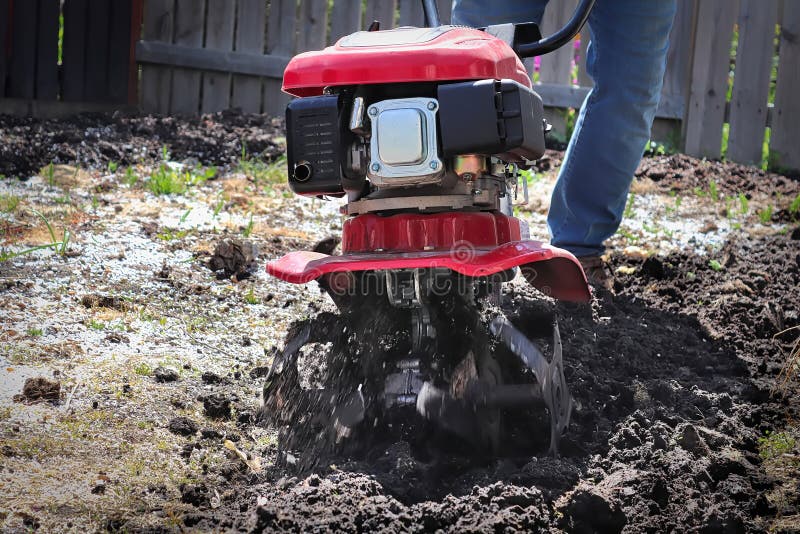 Cultivating Garden Soil in the Spring with a Rototiller Stock Image