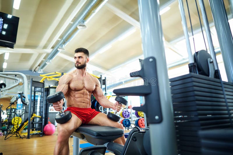 Culturista con le teste di legno nella palestra immagini stock libere da diritti Culturista con le teste di legno nella palestra immagini stock libere da diritti