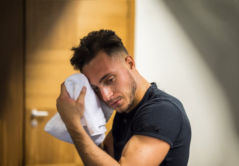 Culturista muscolare che asciuga il suo fronte dopo l'allenamento in una palestra fotografie stock Culturista muscolare che asciuga il suo fronte dopo l'allenamento in una palestra fotografie stock