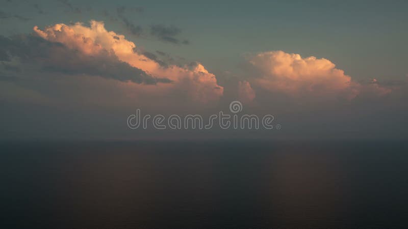 Cumuli rosa sopra il mare al tramonto