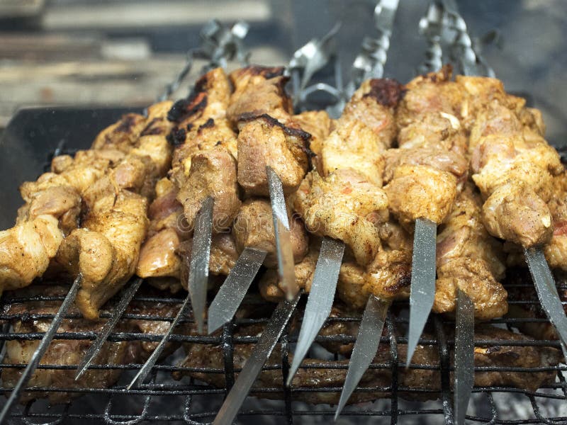 Cuochi della carne sui carboni caldi nel fumo Picnic in natura fotografie stock Cuochi della carne sui carboni caldi nel fumo Picnic in natura fotografie stock