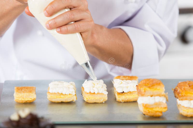 Chef decorating with a pastry bag with cream. Chef decorating with a pastry bag with cream