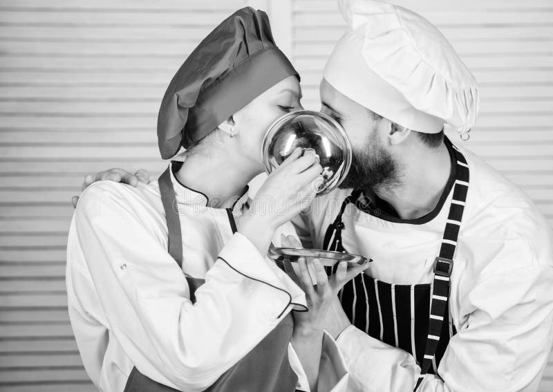 Cuoco unico della donna e dell'uomo in ristorante dietro il vassoio metallico Ingrediente segreto dalla ricetta Uniforme del cuoc immagine stock Cuoco unico della donna e dell'uomo in ristorante dietro il vassoio metallico Ingrediente segreto dalla ricetta Uniforme del cuoc immagine stock