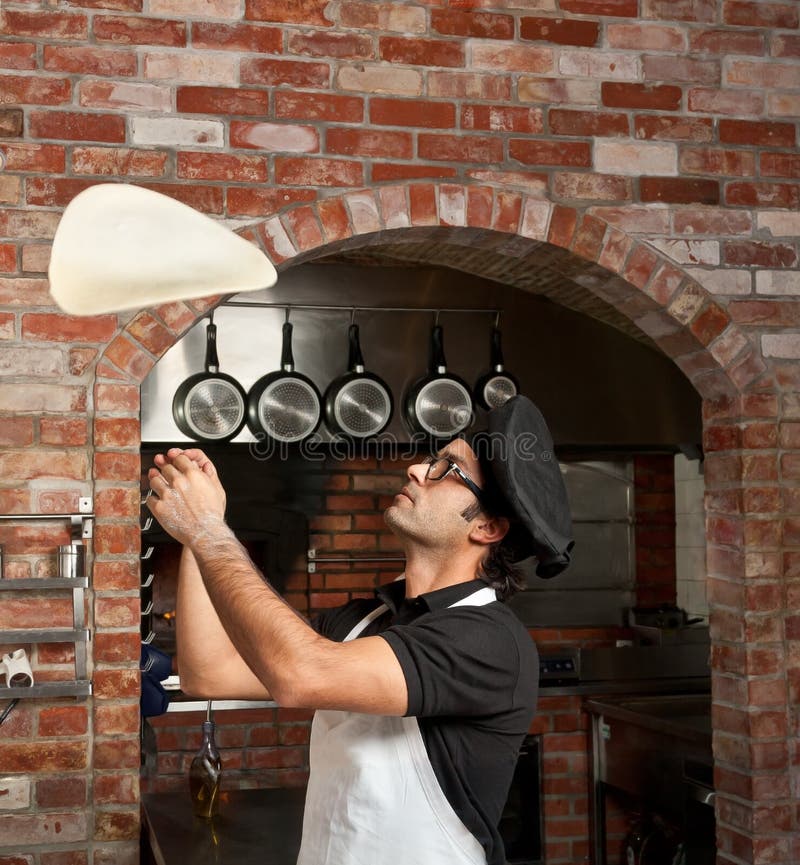 Cuoco unico della pizza che gioca con la pasta della pizza fotografia stock libera da diritti Cuoco unico della pizza che gioca con la pasta della pizza fotografia stock libera da diritti