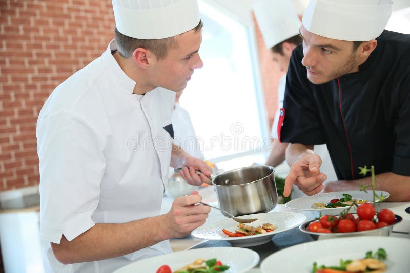 Cuoco unico e cucinare discussione dell'apprendista immagini stock Cuoco unico e cucinare discussione dell'apprendista immagini stock
