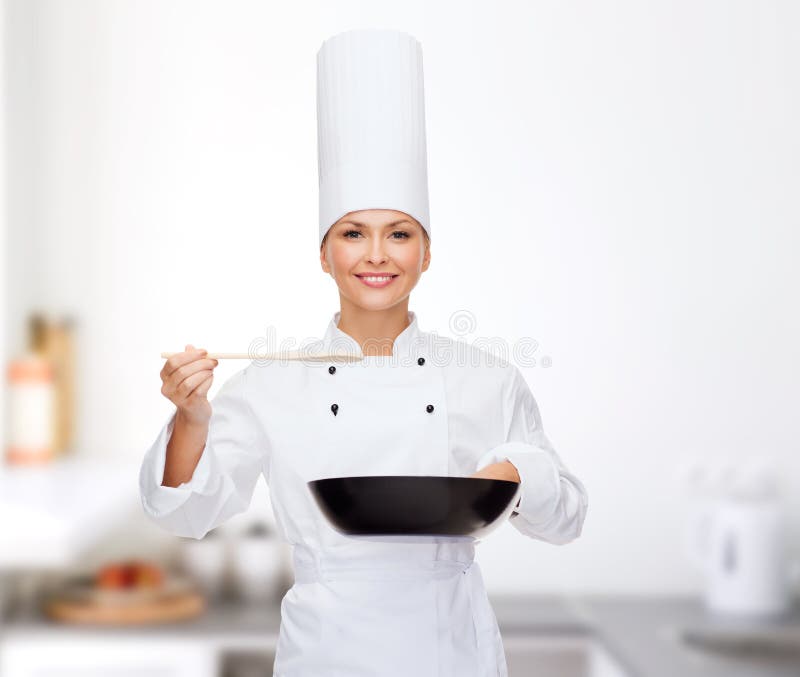 Cooking and food concept - smiling female chef with pan and spoon tasting food. Cooking and food concept - smiling female chef with pan and spoon tasting food.