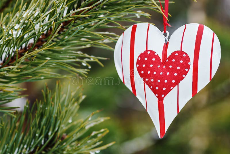 Cuore del giocattolo che appende su un albero di inverno fotografia stock libera da diritti Cuore del giocattolo che appende su un albero di inverno fotografia stock libera da diritti