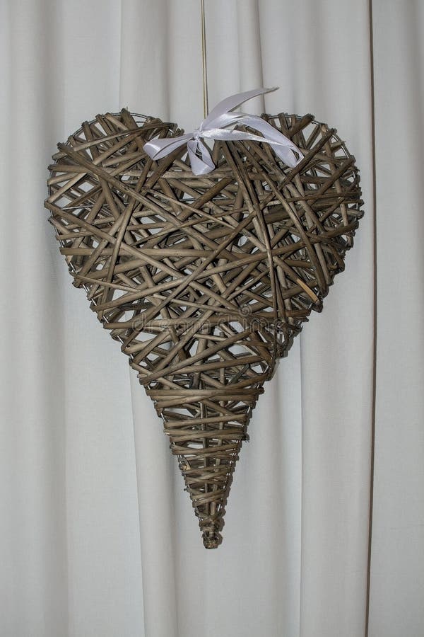 Cuore del rattan di Brown con l'arco bianco fotografie stock libere da diritti