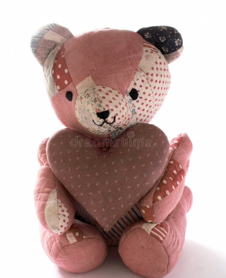 Teddy bear made from antique quilts holding a large mauve calico heart. Teddy bear made from antique quilts holding a large mauve calico heart