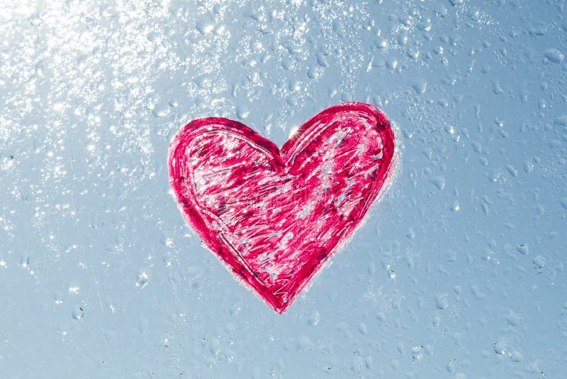 Cuore rosso dipinto con rossetto sulla finestra con le gocce di acqua Il cielo soleggiato blu del fondo, gocce splende al sole fotografia stock libera da diritti Cuore rosso dipinto con rossetto sulla finestra con le gocce di acqua Il cielo soleggiato blu del fondo, gocce splende al sole fotografia stock libera da diritti