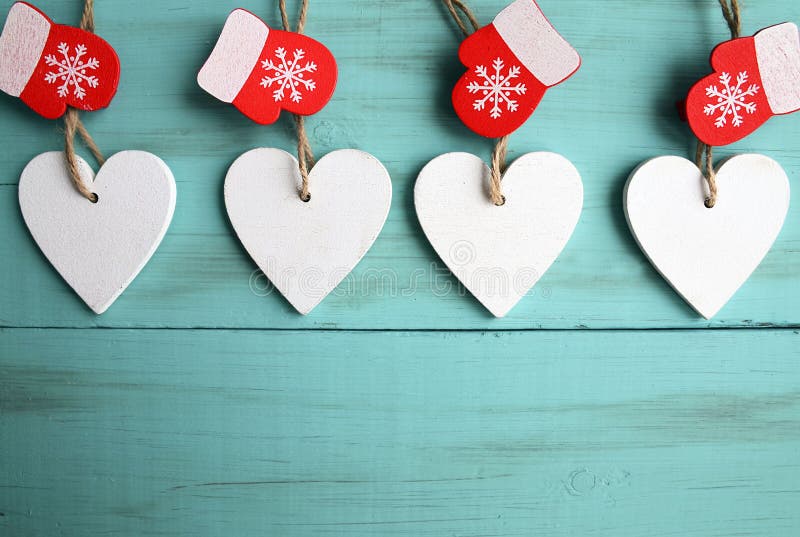 Cuori di legno bianchi decorativi di Natale e guanti rossi su fondo di legno blu con lo spazio della copia fotografia stock Cuori di legno bianchi decorativi di Natale e guanti rossi su fondo di legno blu con lo spazio della copia fotografia stock