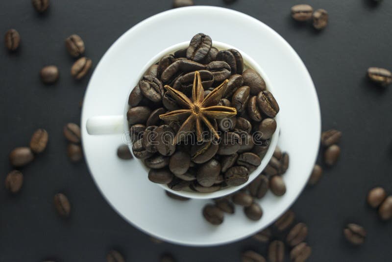 Cup of Black Coffee with Foam on Background of Roasted Coffee Beans