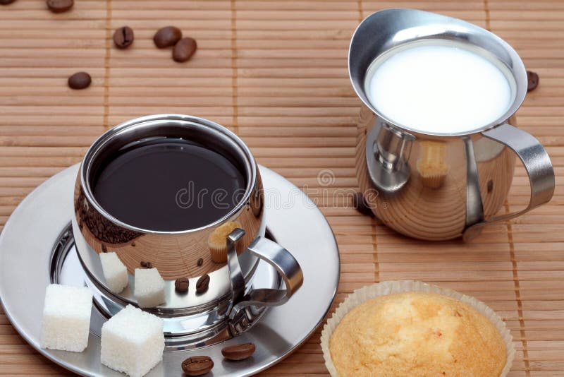 Cup of black coffee with muffin and milk