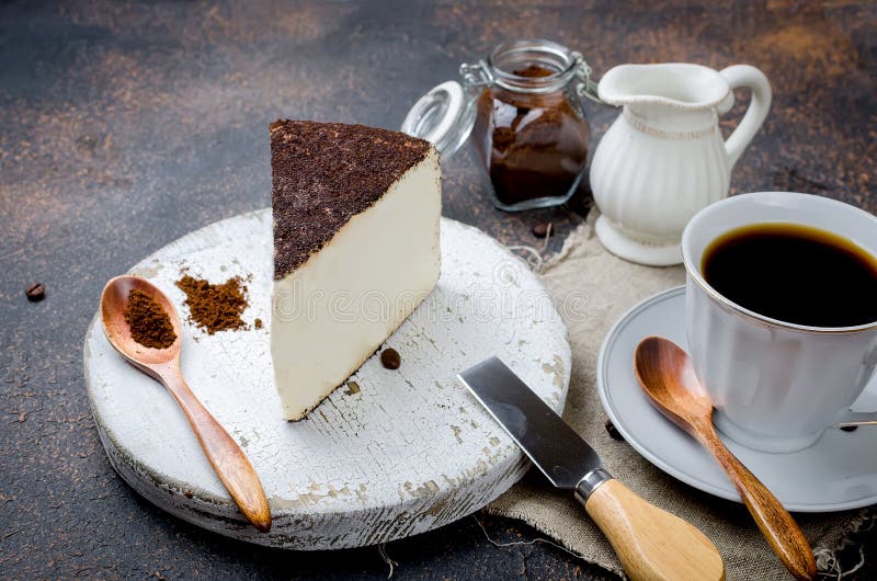 Cup of Black Coffee with a Piece of Soft Cheese in Ground Coffee Stock