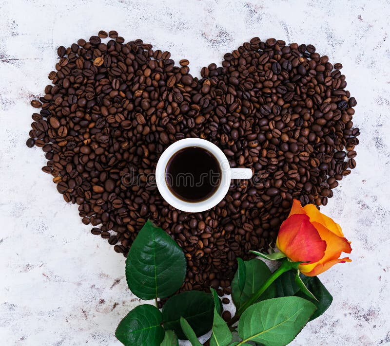 Cup of coffee and rose on a white background. Top view