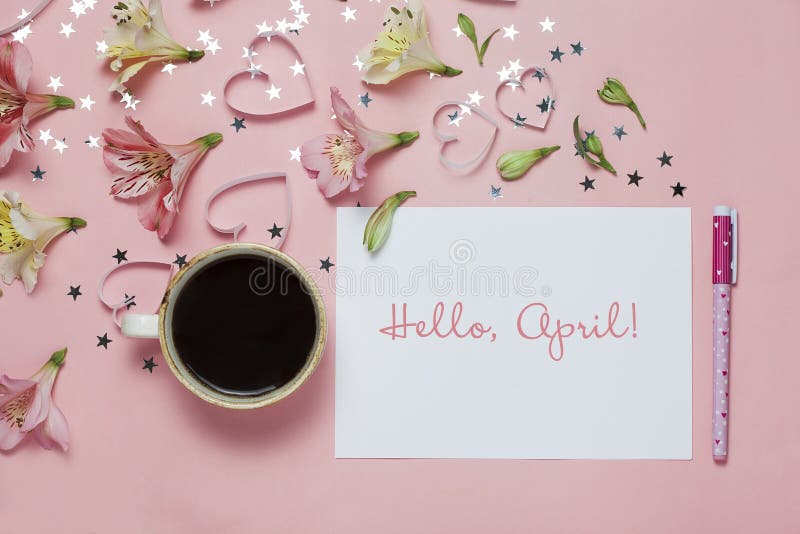 Cup of coffe and spring greeting with a pen, flower composition and words Hello April on pink background. top view, flat lay royalty free stock photography Cup of coffe and spring greeting with a pen, flower composition and words Hello April on pink background. top view, flat lay royalty free stock photography
