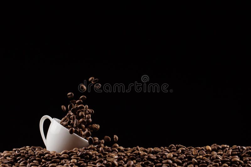 A cup with coffee beans in the air flying in flight like a spray. On a black background, coffee shop advertising concept, copy