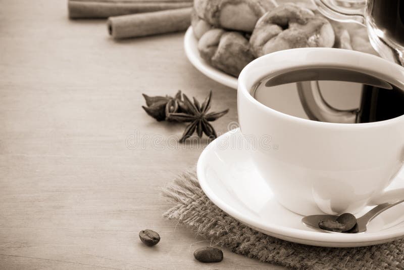 Cup of coffee with beans and cakes on wood