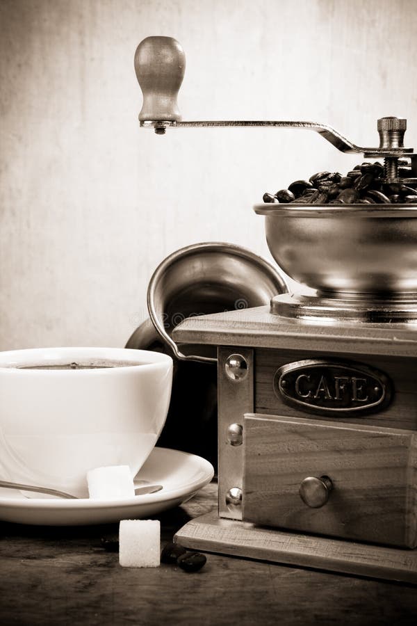 Cup of coffee, beans, pot and grinder on wood