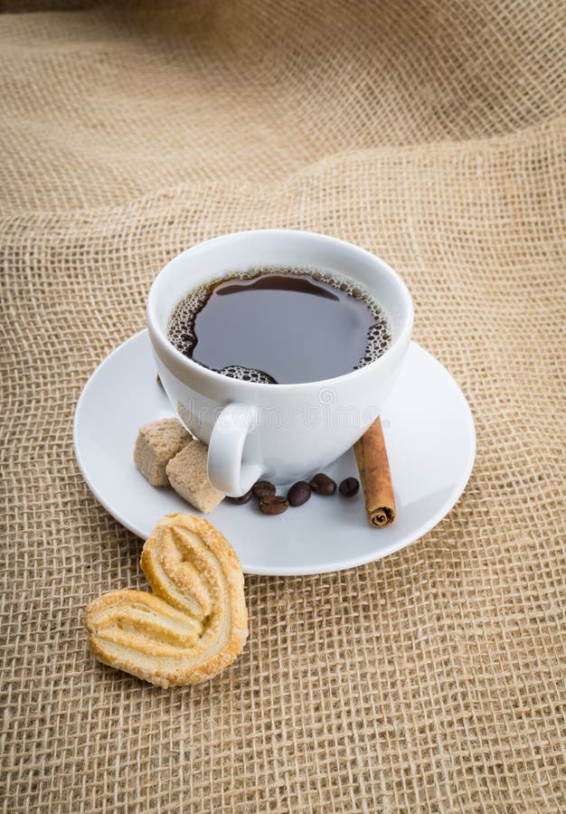 Cup of coffee, cookie on sackcloth background. Espresso, arabica.