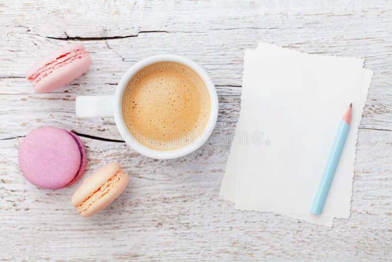 Cup of coffee with macaron and blank sheets on white wooden table from above, flat lay royalty free stock photography Cup of coffee with macaron and blank sheets on white wooden table from above, flat lay royalty free stock photography