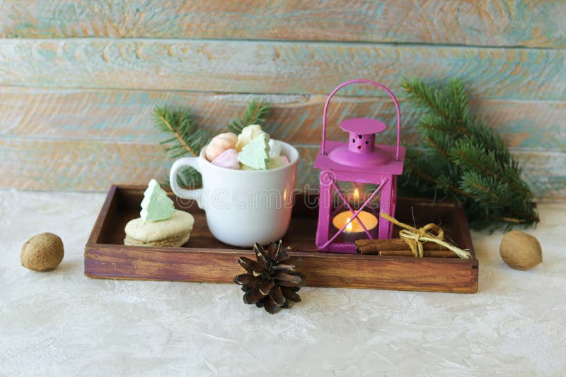 Cup of coffee with meringue and dessert, Christmas decor, lantern with a burning candle, on a wooden table, the concept of home co