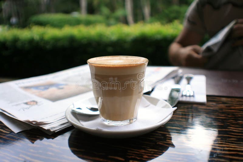 Cup of coffee with news paper on table