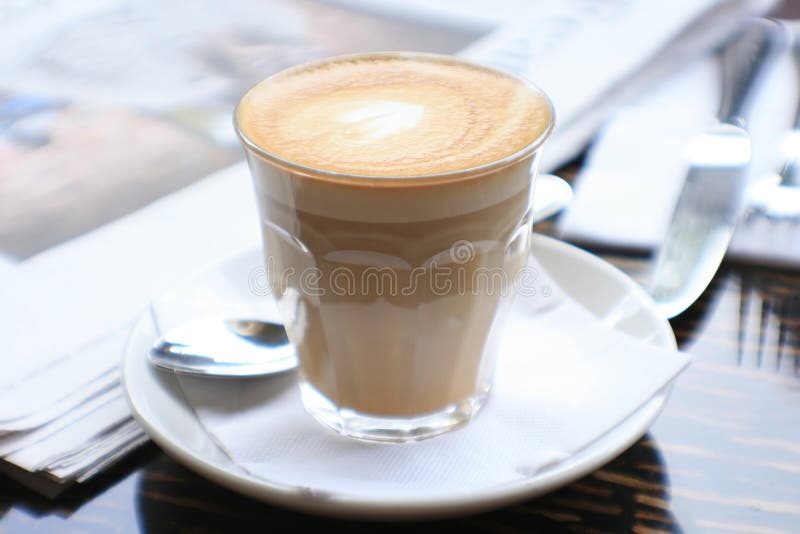 Cup of coffee with news paper on table