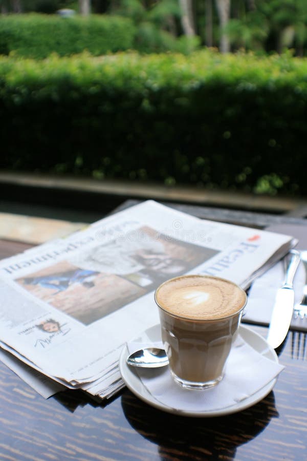 Cup of coffee with news paper on table