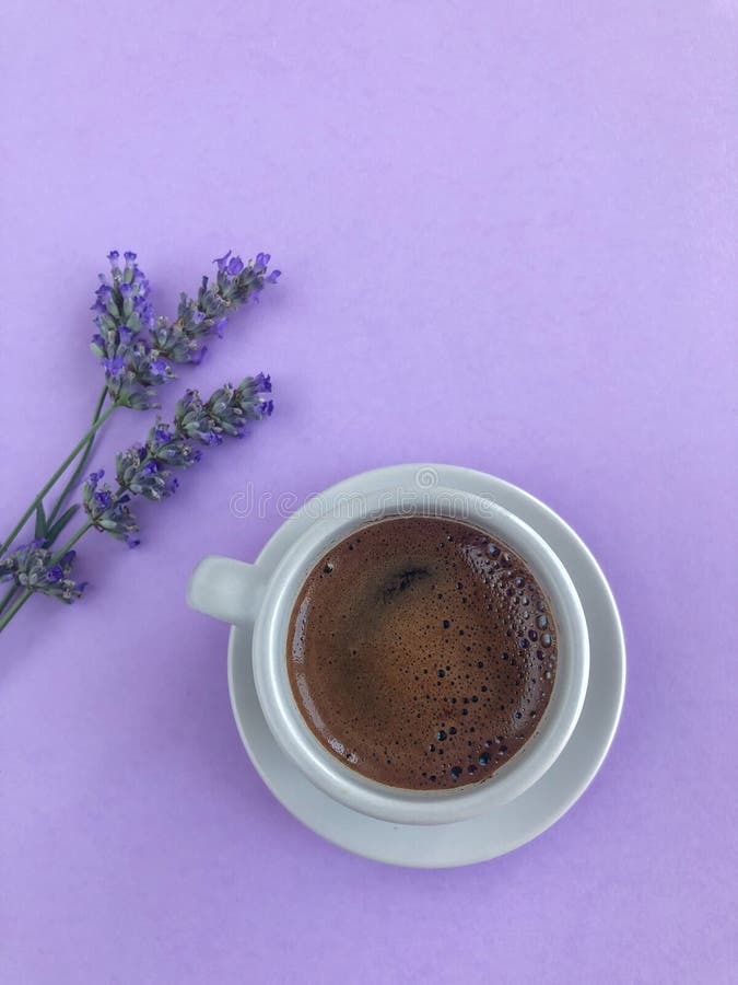 Cup of Coffee on Purple Background Decorated with Lavender Flowers
