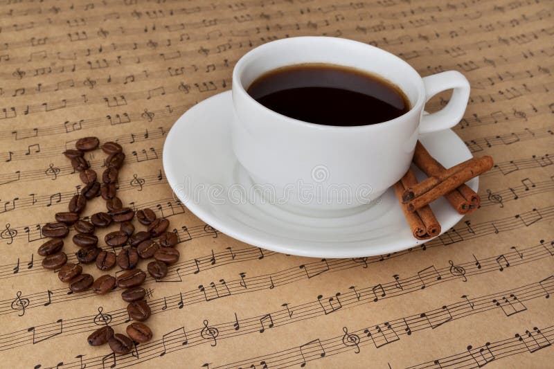 Cup of Coffee on Sheet Music with Cinnamon and Beans Stock Photo