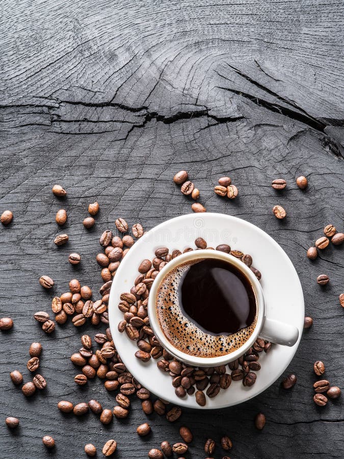 Cup of coffee surrounded by coffee beans. Top view. royalty free stock image