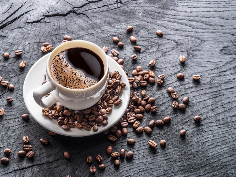 Cup of coffee surrounded by coffee beans. Top view stock image