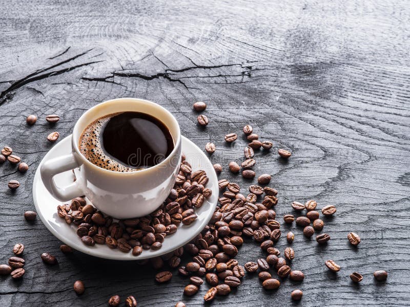 Cup of coffee surrounded by coffee beans. Top view royalty free stock photos