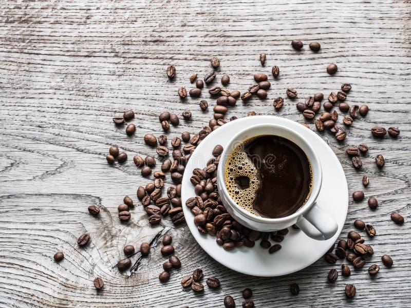 Cup of coffee surrounded by coffee beans. Top view stock image