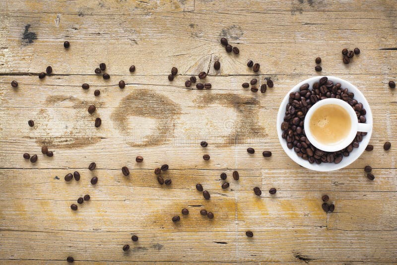 A cup of coffee surrounded by coffe beans royalty free stock photography
