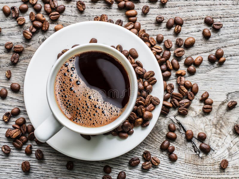 Cup of coffee surrounded by coffee beans. Top view. royalty free stock photo