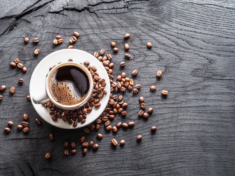 Cup of coffee surrounded by coffee beans. Top view royalty free stock image