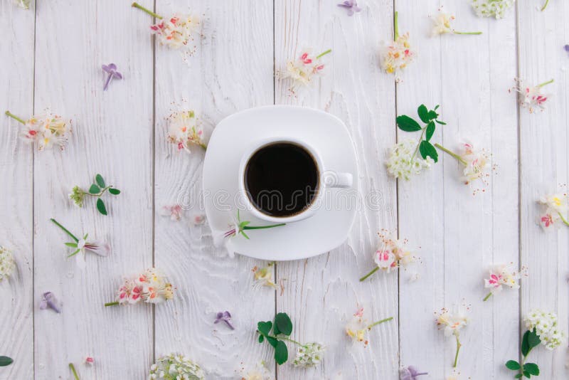 Cup of coffee surrounded with flowers stock photo