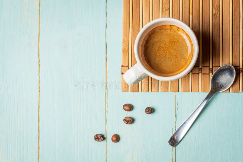 Cup of Coffee Teaspoon and Coffee Beans on Green Background Stock Photo